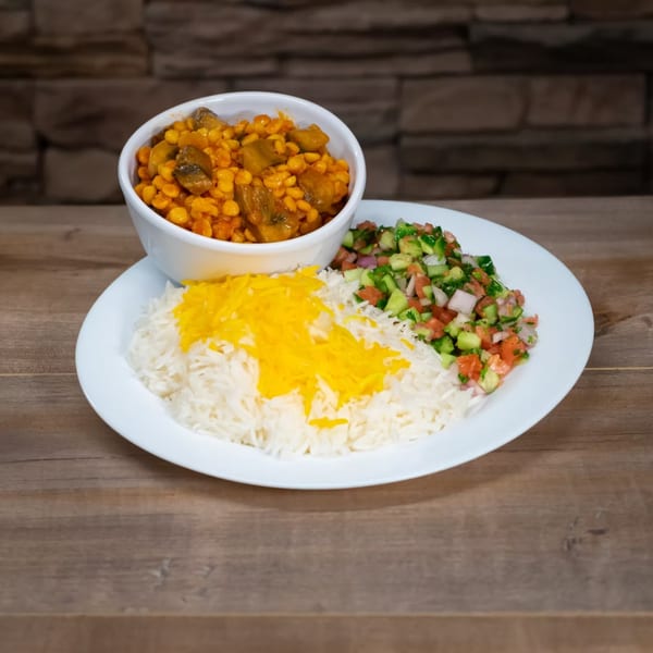 A Mediterranean dish with rice, yellow saffron, a side salad, and a bowl of stew.