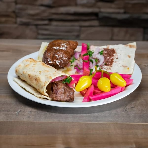 York Kabob's Mediterranean dish with meat, flatbread, pickled onions, and bright pink and yellow vegetables.