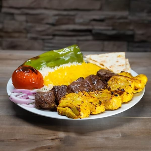 A York Kabob platter with yellow and white rice, grilled meats, bell pepper, tomato, and flatbread.